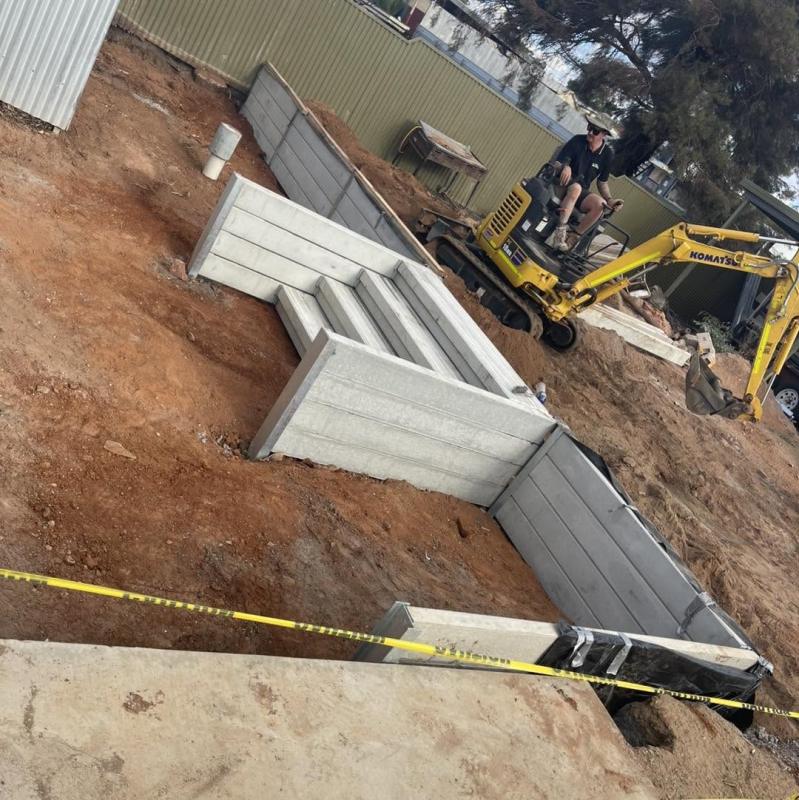 Concrete sleeper retaining wall with a custom step kit, dug and set with our own excavator